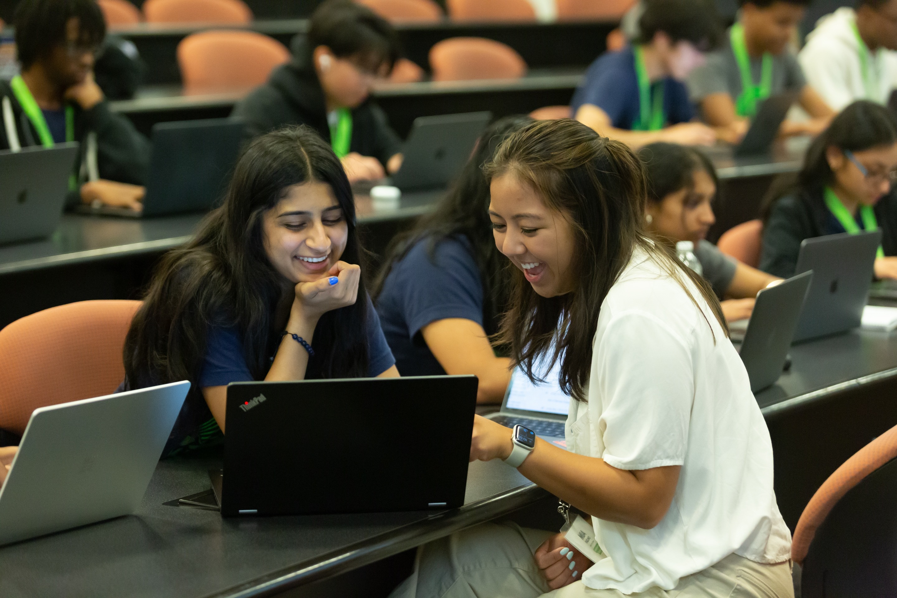 Students in lecture auditorium with laptops