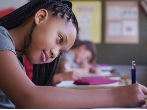 Girl writing in classroom